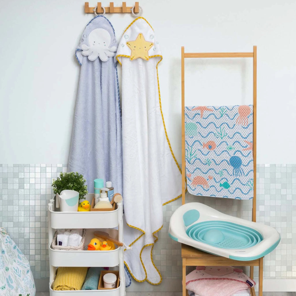 Children's bathroom with towels, a bathtub, and a shelf.
