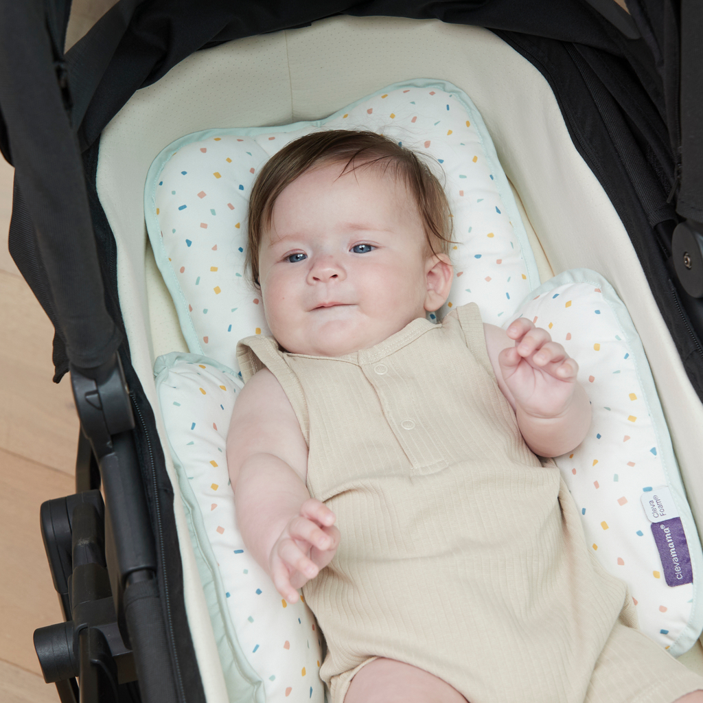 Baby lying in stroller bassinet on ClevaFoam head & neck support.