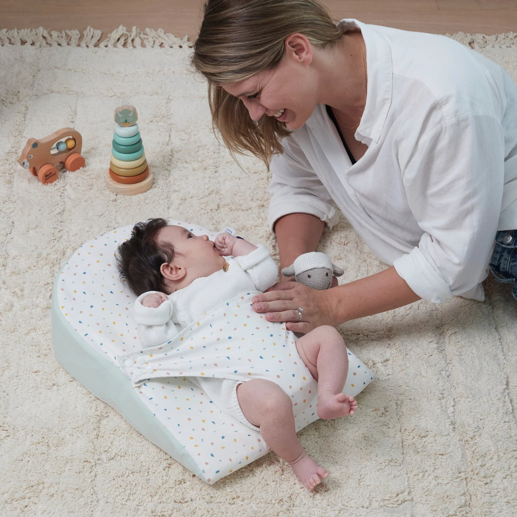 Mum chatting with baby lying on ClevaMama ClevaFoam Reflux Wedge